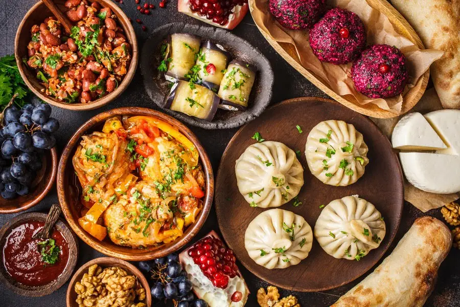 A spread of traditional Georgian food, including Khinkali and Khachapuri, highlighting why travelers should visit Georgia for its world-renowned tourism and culinary heritage